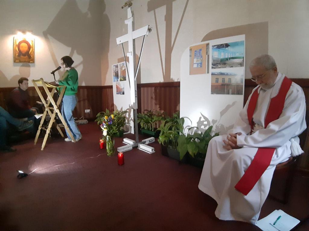 Chemin de croix à Lviv: prier devant la croix réalisée avec le montant de fenêtre d'une école bombardée à Irpin